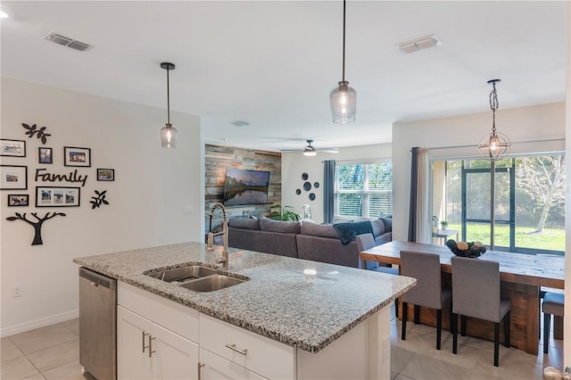 kitchen with stainless steel dishwasher, a sink, visible vents, and decorative light fixtures