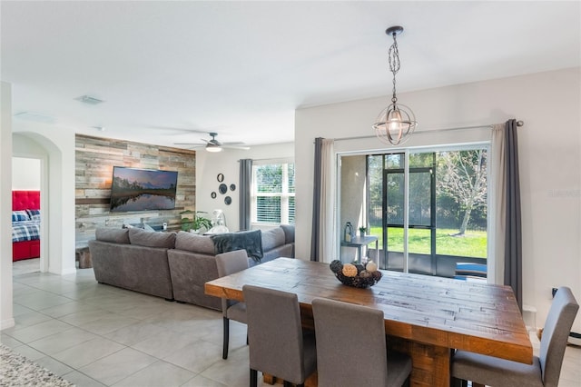 dining space featuring an accent wall, visible vents, ceiling fan, and light tile patterned floors