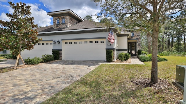 view of front facade with stone siding, an attached garage, decorative driveway, a front yard, and stucco siding