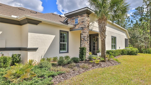 view of property exterior with stone siding, a lawn, and stucco siding