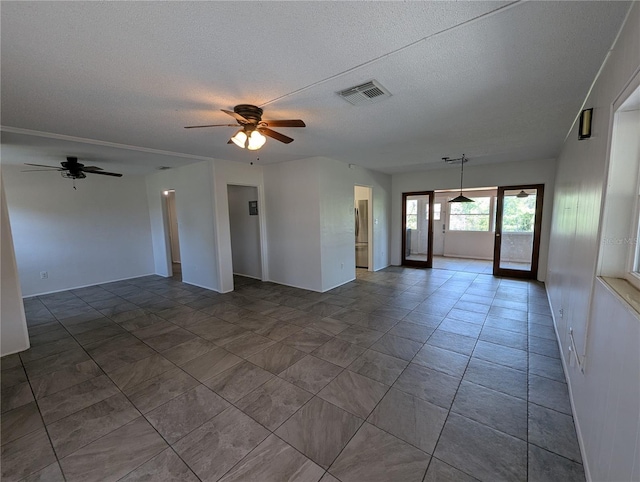 empty room with visible vents, ceiling fan, and a textured ceiling