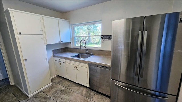 kitchen featuring stainless steel appliances, a sink, light countertops, and white cabinets