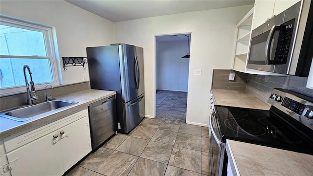 kitchen featuring white cabinets, appliances with stainless steel finishes, open shelves, and a sink