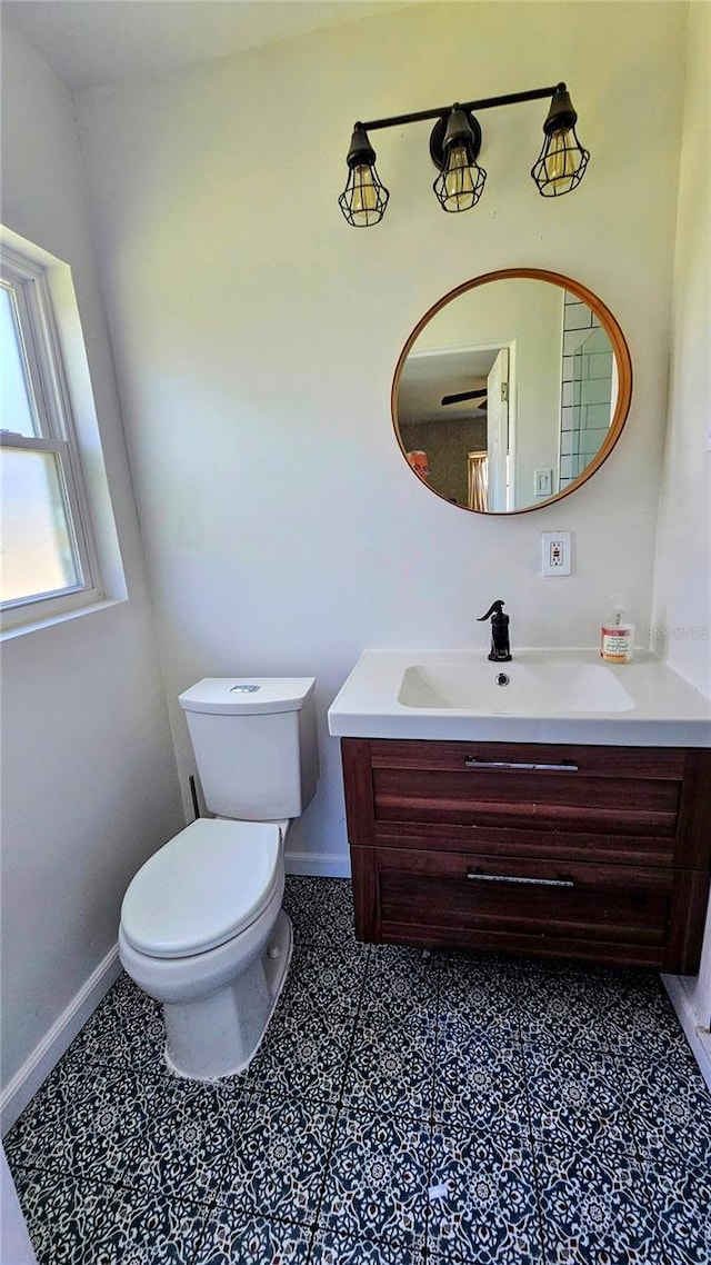 bathroom with baseboards, vanity, and toilet