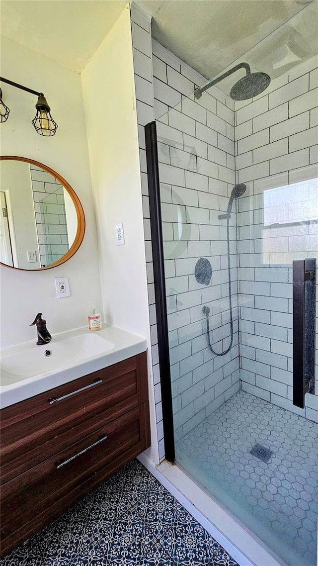 bathroom with a tile shower and vanity