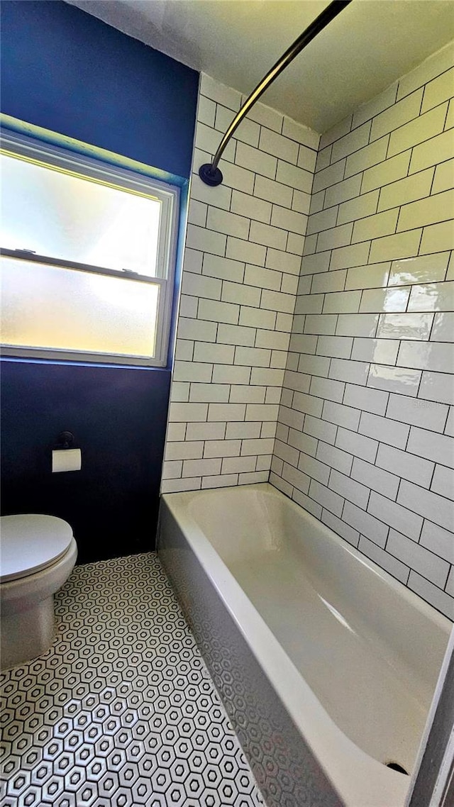 bathroom with toilet, bathtub / shower combination, and tile patterned floors