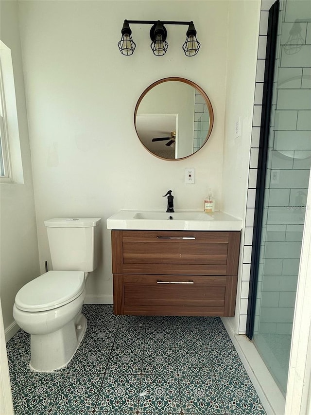 bathroom with ceiling fan, toilet, vanity, baseboards, and tile patterned floors