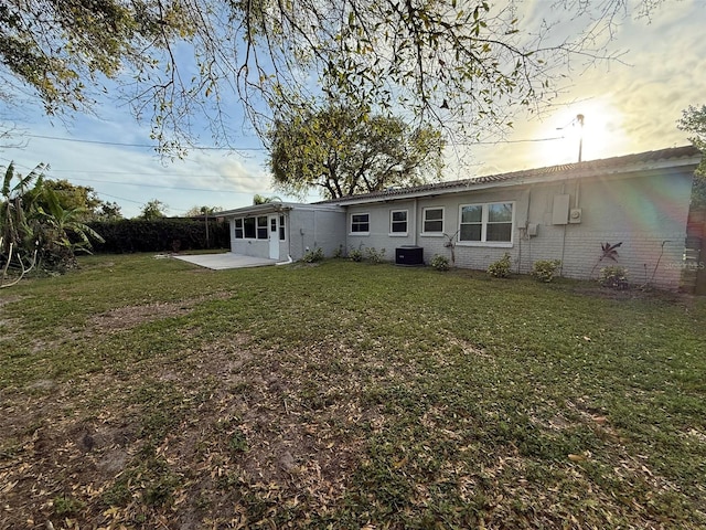 rear view of property with a patio area, brick siding, a lawn, and fence