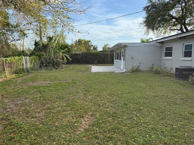 view of yard with a fenced backyard, central AC unit, and a patio