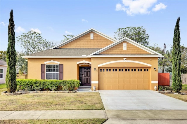 view of front facade featuring driveway, a garage, roof with shingles, a front lawn, and stucco siding