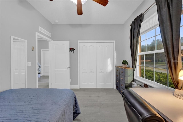 bedroom with visible vents, baseboards, a ceiling fan, a closet, and light wood finished floors