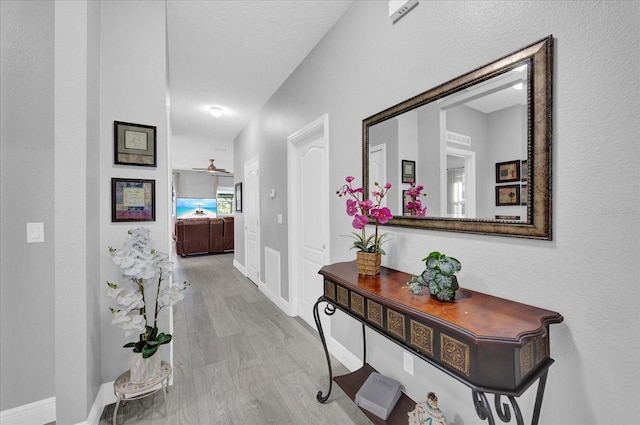 corridor featuring baseboards and wood finished floors