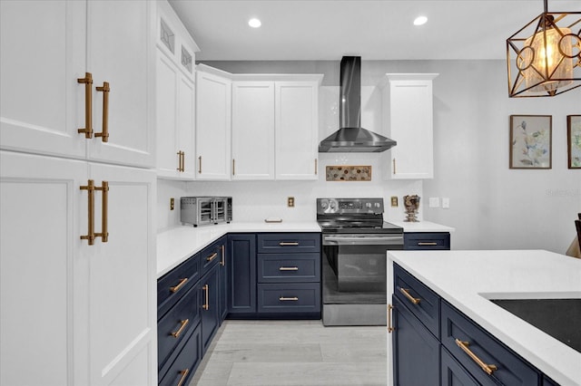 kitchen with electric stove, white cabinets, blue cabinetry, and wall chimney exhaust hood