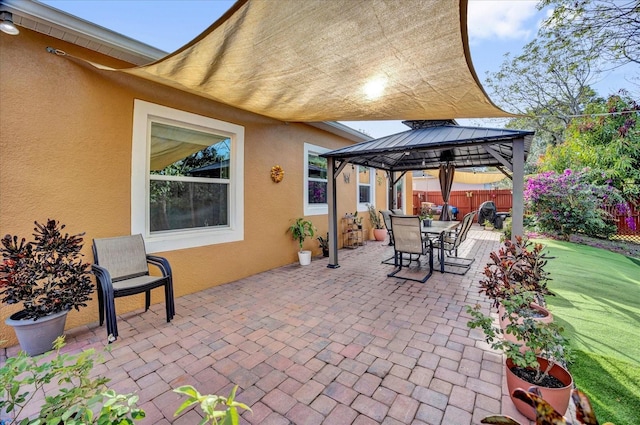 view of patio / terrace featuring fence, outdoor dining area, and a gazebo