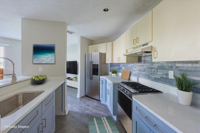 kitchen with tasteful backsplash, visible vents, appliances with stainless steel finishes, under cabinet range hood, and a sink