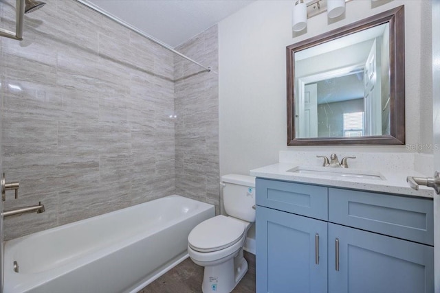 bathroom featuring washtub / shower combination, vanity, and toilet