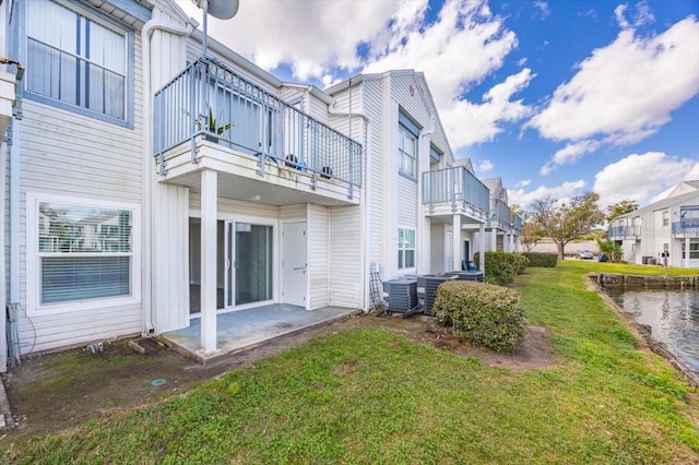 back of property featuring a patio, cooling unit, a water view, a lawn, and a residential view