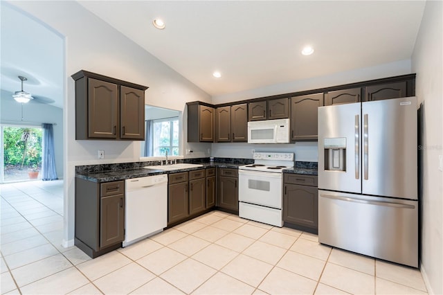 kitchen with vaulted ceiling, white appliances, a healthy amount of sunlight, and a sink