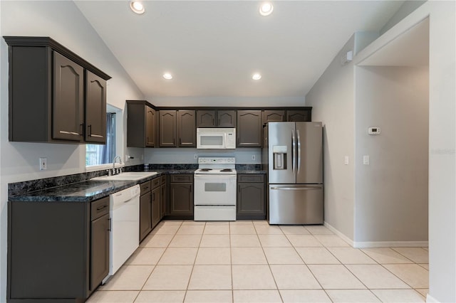 kitchen featuring lofted ceiling, white appliances, light tile patterned flooring, and a sink