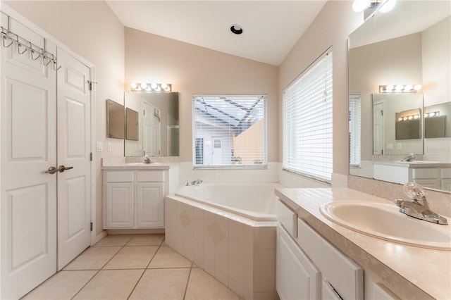 bathroom featuring vaulted ceiling, a sink, a bath, and tile patterned floors