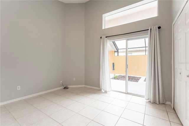 unfurnished room with baseboards and light tile patterned floors