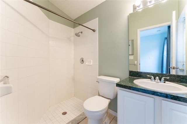 bathroom with toilet, lofted ceiling, tiled shower, and vanity