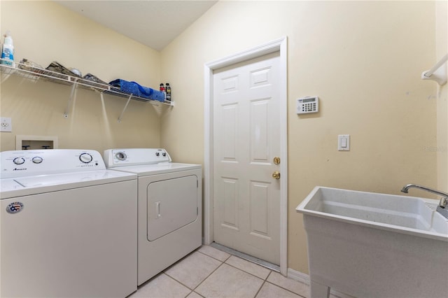 laundry area featuring laundry area, light tile patterned flooring, a sink, and washer and dryer