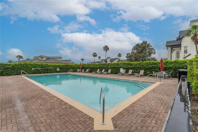 pool with a patio area and fence