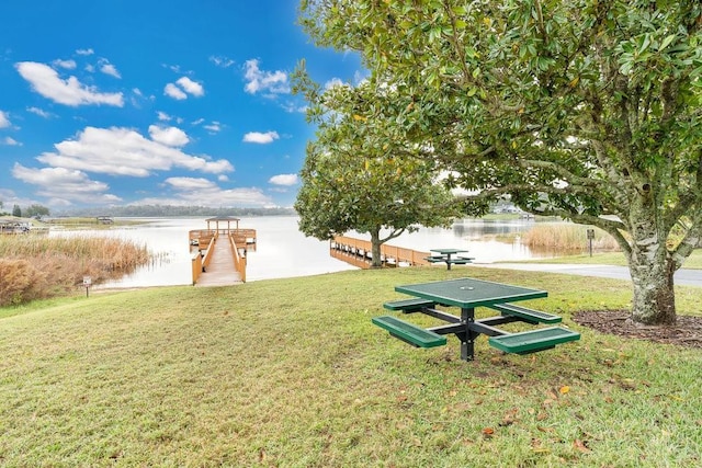 view of property's community with a yard, a boat dock, and a water view