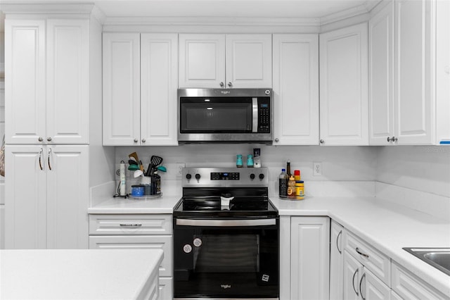 kitchen featuring stainless steel appliances, light countertops, and white cabinets