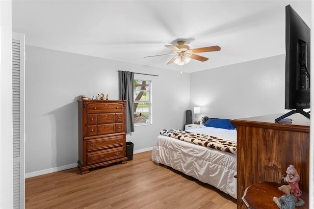 bedroom with a ceiling fan, baseboards, and wood finished floors