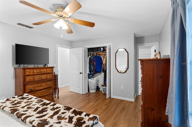 bedroom featuring baseboards, visible vents, a ceiling fan, light wood-style flooring, and a closet