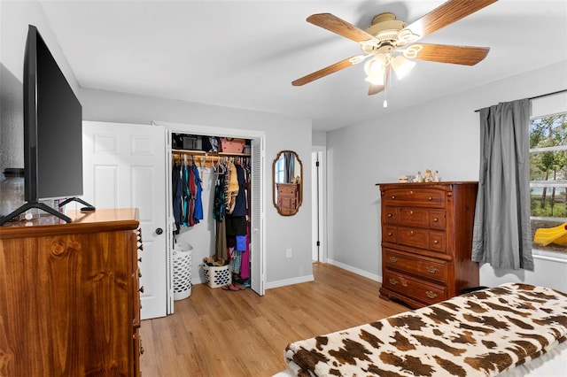 bedroom featuring a ceiling fan, light wood-style flooring, baseboards, and a closet