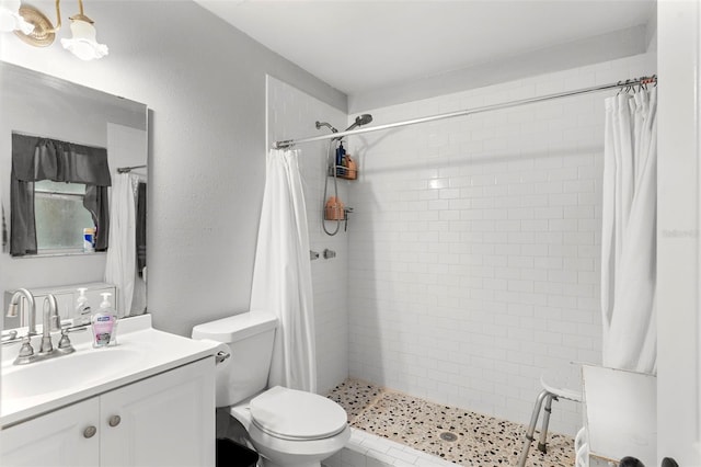 bathroom with a stall shower, a textured wall, vanity, and toilet