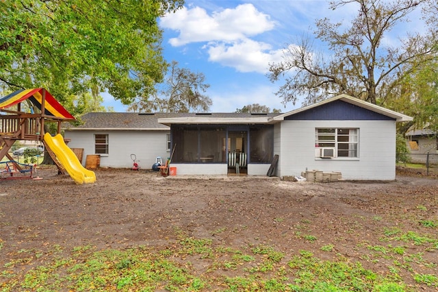 view of front of home featuring a playground, cooling unit, and a sunroom