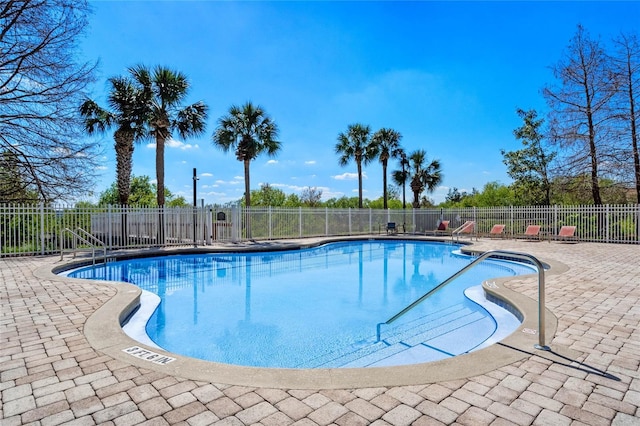 community pool featuring a patio and fence