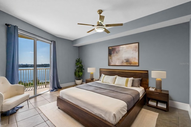 tiled bedroom with access to exterior, a water view, ceiling fan, and baseboards