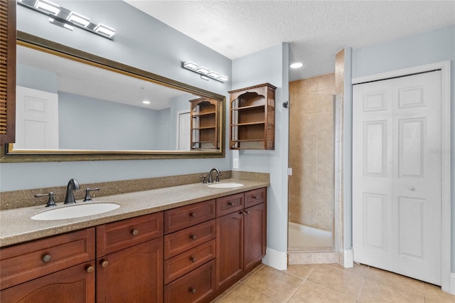 bathroom with a sink, a shower stall, and tile patterned floors