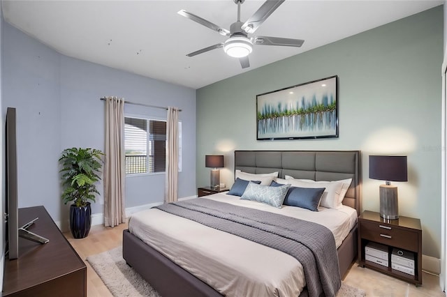 bedroom with baseboards, a ceiling fan, and light wood-style floors