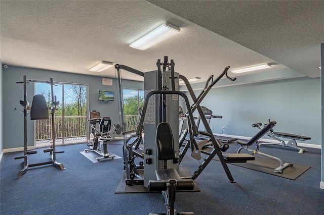 exercise room featuring baseboards and a textured ceiling