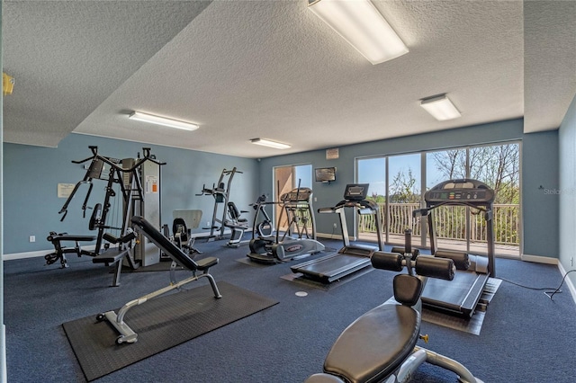 workout area with a textured ceiling and baseboards