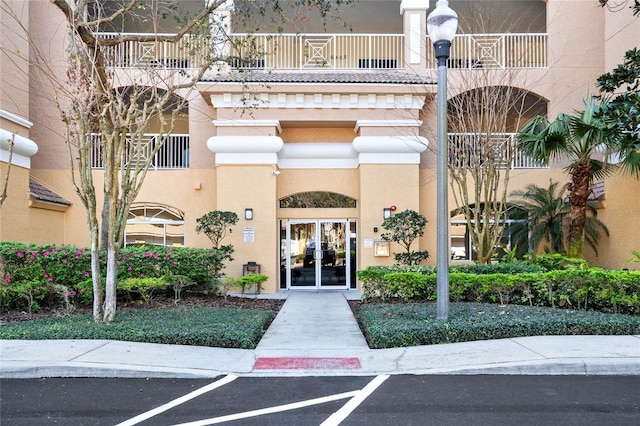 view of exterior entry featuring stucco siding and french doors