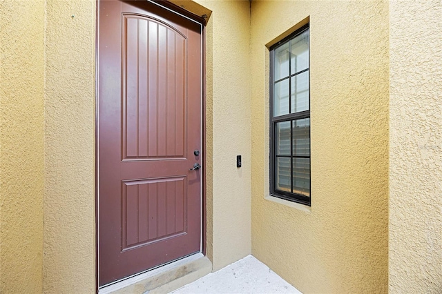 entrance to property featuring stucco siding