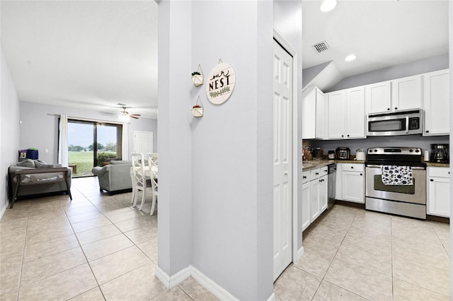 kitchen with light tile patterned floors, stainless steel appliances, white cabinetry, and a ceiling fan