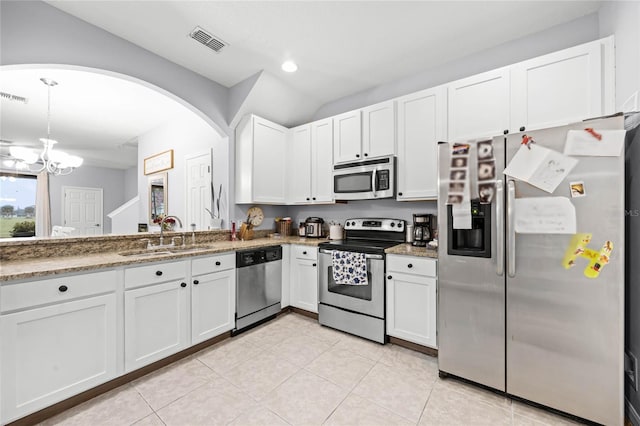 kitchen with light tile patterned floors, stainless steel appliances, visible vents, white cabinetry, and a sink