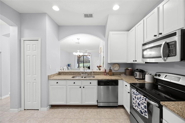 kitchen with appliances with stainless steel finishes, a sink, visible vents, and white cabinets