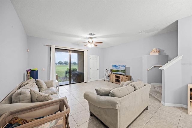 living room with light tile patterned floors, stairs, visible vents, and a textured ceiling