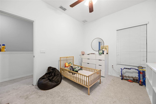 carpeted bedroom with a nursery area, visible vents, and a ceiling fan