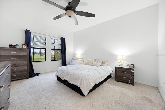 bedroom with baseboards, a ceiling fan, and light colored carpet