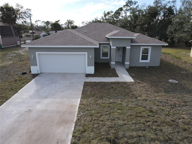 view of front of home featuring an attached garage, a shingled roof, concrete driveway, and stucco siding